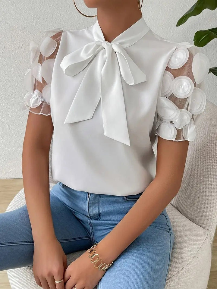 Elegant women’s blouse with a bow and sheer sleeves.
