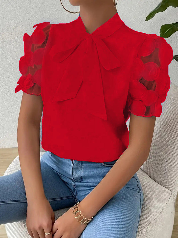 Elegant women’s blouse with a bow and sheer sleeves.
